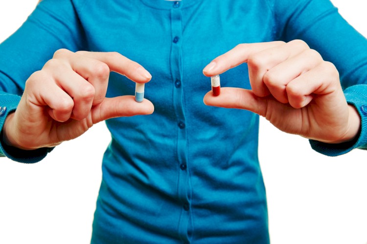 Man Holding Two Different Pills