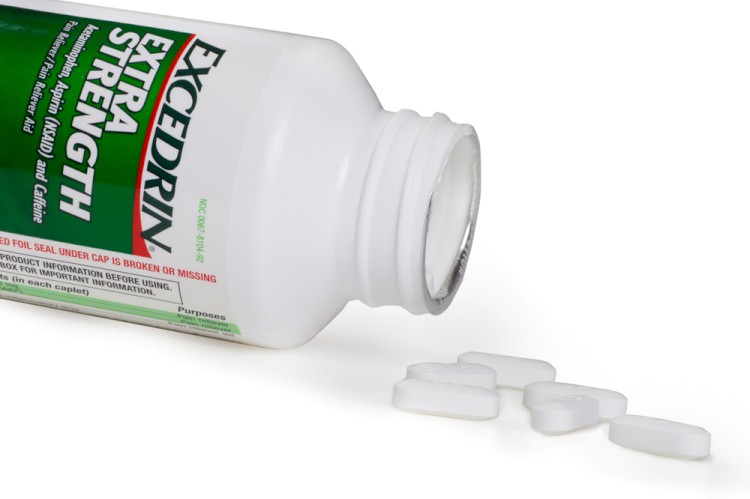 Bottle of Excedrin Extra Strength aspirin and tablets against white background